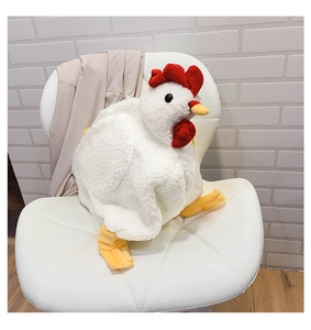 Detailed view of plush chicken bag with yellow beak on white quilted leather chair