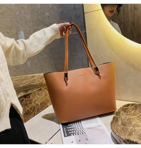 Détail du sac cabas en cuir marron avec texte FASHION sur surface marbre