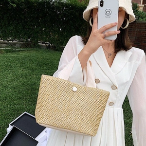 Handmade straw tote bag with white ribbon handles for summer beach vacations and daily use