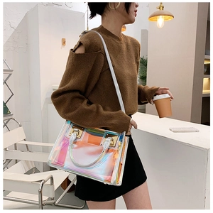 Detail of holographic laser tote bag with white leather handles and shoulder strap