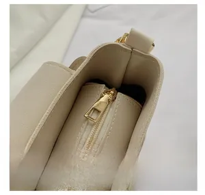 Detail shot of golden metal zipper pull and premium lychee grain leather texture