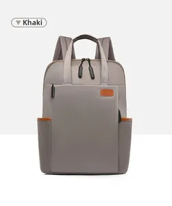 Detailed view of khaki Oxford cloth backpack with leather accents and side pockets