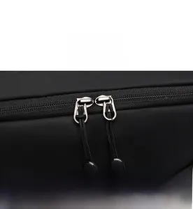 Close-up of smooth two-way metal zippers with black pull cords on a nylon backpack