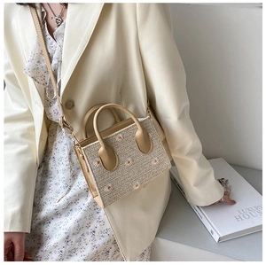Détail du sac cabas en paille avec broderie marguerite blanche et poignée en cuir
