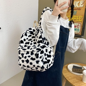 Fuzzy cow print plush backpack for women with adjustable straps and front pocket