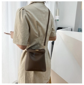 Detailansicht der dunkelbraunen Lederbeuteltasche mit modischer Prägung und Riemen