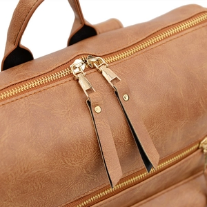 Vue macro détaillée du sac à dos en cuir marron avec des fermetures éclair en métal doré de qualité