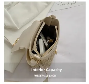 Detail view of woven crossbody bag interior capacity with a zipper pocket and golden hardware