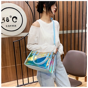 Detail of laser iridescent PVC tote bag with sky blue leather trim and golden metal clasp