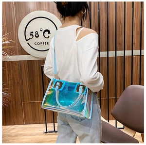 Detailed shot of holographic PVC tote bag with light blue leather trim and metal buckles