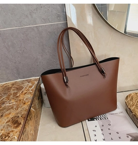 Gros plan détaillé du sac cabas en cuir marron foncé avec logo FASHION sur marbre chic