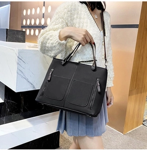 Chic black matte leather tote bag with dual front zipper pockets shown with model