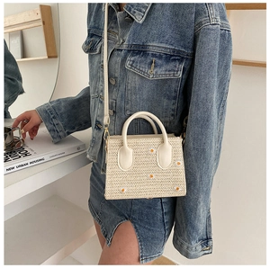 Détail du sac cabas en paille avec broderie marguerite et bandoulière en cuir