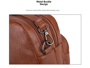 Detail of metal hook buckle and detachable shoulder strap on brown textured leather bag