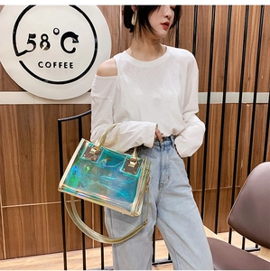 Detailed view of laser holographic transparent tote bag with golden metal handles and strap