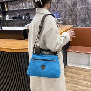 Blue canvas travel bag for men with adjustable shoulder strap and leather logo detail