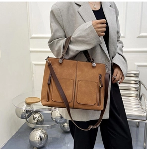 Close-up of vintage brown frosted leather tote bag with functional double zipper pockets