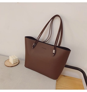 Gros plan détaillé du sac cabas marron foncé avec texte Fashion sur une table grise