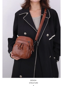Adjustable leather strap and multi-pocket detail on a vintage brown crossbody bag