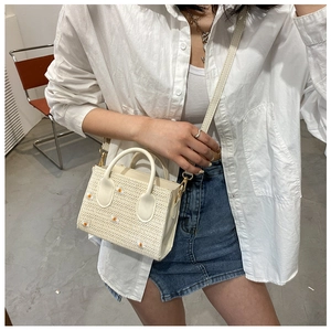 Détail du sac cabas en paille blanc cassé avec broderie marguerite et anses