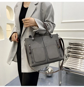 Macro detail of the dark gray tote bag showing matte texture and double front flap pockets