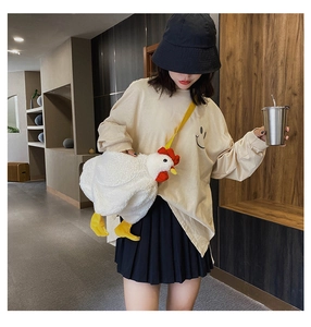 Detail of cute white plush chicken bag featuring red comb and adjustable yellow strap