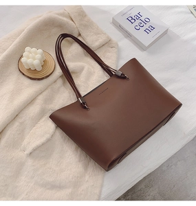 Grand sac cabas marron sur tapis blanc avec livre et bougie pour un look chic