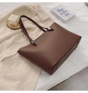 Détail du cabas en cuir mat marron foncé avec texte mode embossé sur surface texturée