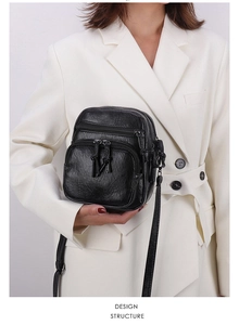 Detail of black pleated PU leather crossbody bag with double exterior zipper pockets