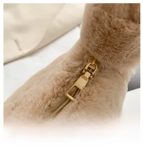 Vue macro détaillée de la fermeture éclair en métal doré sur le sac en peluche beige