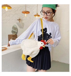 Detail of plush chicken shoulder bag with white fleece texture and yellow strap