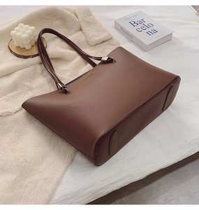 Détail d'un cabas en cuir marron foncé avec surface texturée et marquage Fashion