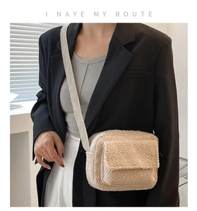 Détail du sac bandoulière en laine d'agneau crème avec texture pelucheuse et sangle