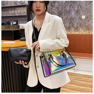 Close-up of holographic transparent tote bag and black inner pouch in a cafe setting