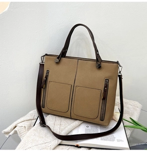Detail of khaki frosted leather tote bag with functional pockets and zipper accents