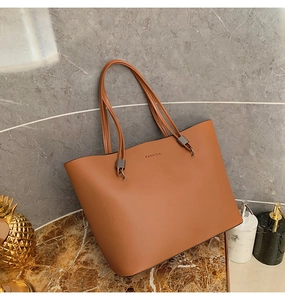 Détail du sac cabas en similicuir marron avec lettrage FASHION et boucle