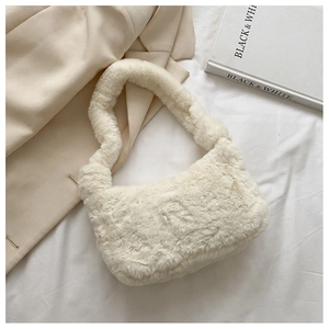 Gros plan du sac sous le bras en peluche blanc cassé sur fond texturé élégant