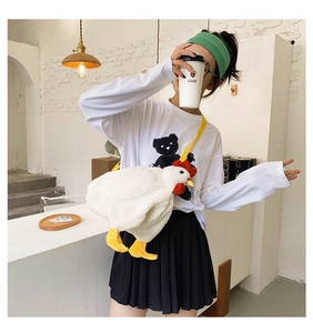 Cute plush chicken crossbody bag shown on a model in a minimalist indoor setting