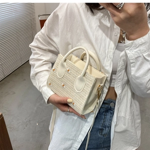 Détail du sac cabas en paille crème avec broderie marguerite et poignées arrondies