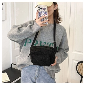 Détail de la bandoulière en polaire noire avec texture douce et sangle réglable
