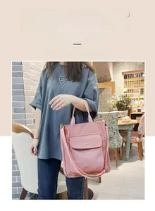 Detail of pink corduroy tote bag featuring adjustable shoulder strap and gold star metal buckle
