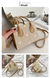 Détail du sac cabas en paille kaki avec broderies marguerites et boucles dorées chic