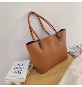 Détail d'un cabas en cuir PU marron avec texte de mode et finitions métalliques élégantes