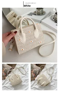 Détail d'un sac cabas en paille tissée avec broderie marguerite et bandoulière