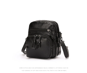 Detail of black PU leather shoulder bag featuring multi-zipper pockets and lychee texture