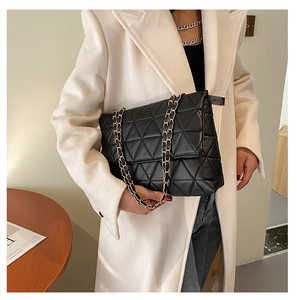 Détail du sac à bandoulière en cuir matelassé noir avec chaîne dorée et fini moderne