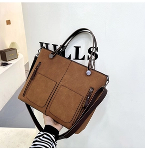 Close-up of brown suede tote bag with double front pockets and metallic zippers