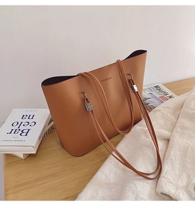Détail d'un sac cabas marron avec texte FASHION et boucle en métal argenté élégante sur cuir