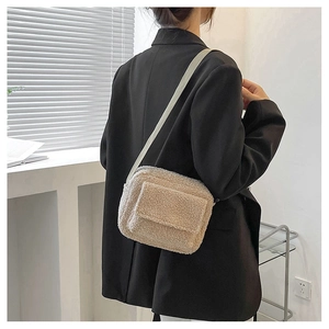 Détail de la texture douce du sac à bandoulière en laine d'agneau beige pour femme
