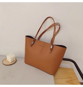 Détail du sac cabas caramel avec boucles argentées et logo fashion en relief